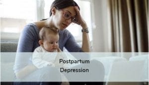 frustrated mom seeks information on computer while holding baby