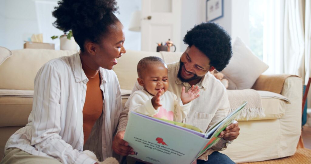 Happy family reading a book with baby